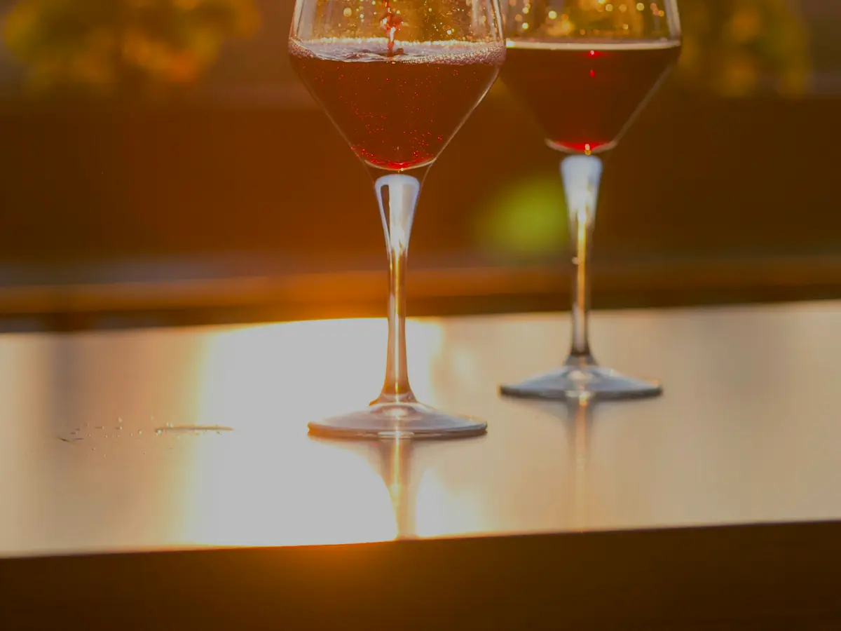 Dos copas brindando a contraluz durante el atardecer